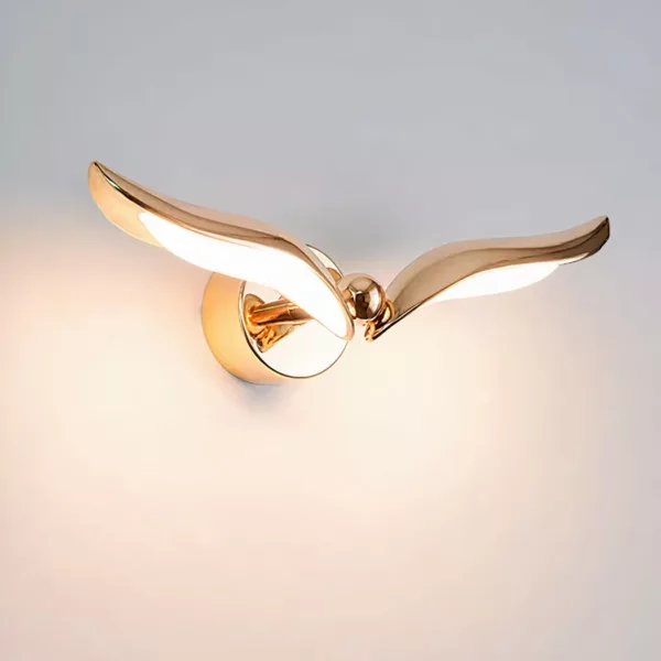 Moderne gouden vogel wandlamp Op een witte achtergrond zien we een verlichte gouden vogel.