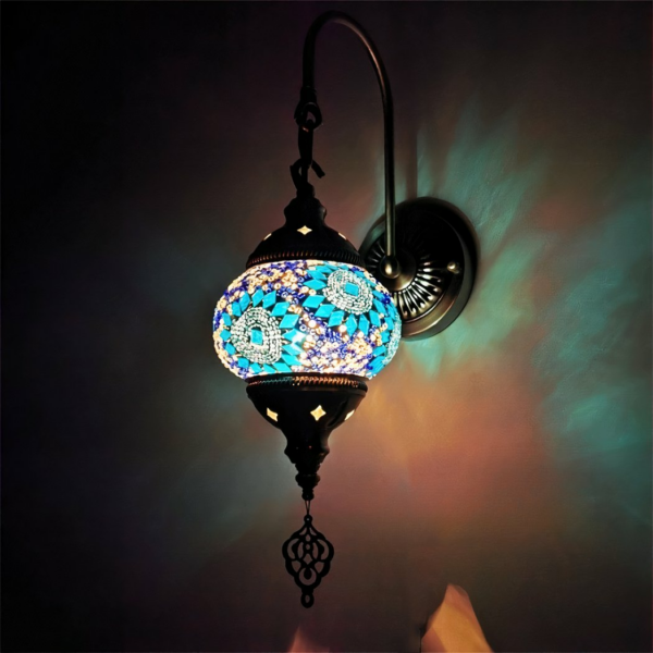 Oosterse wandlamp in blauw glasmozaïek, verlicht in het donker