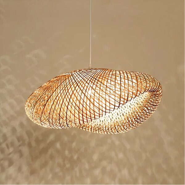 Bamboe kroonluchter met grote, luchtige kap in een modern ontwerp. Met de lamp aan, die schaduwen werpt op de beige muur achter de kroonluchter.