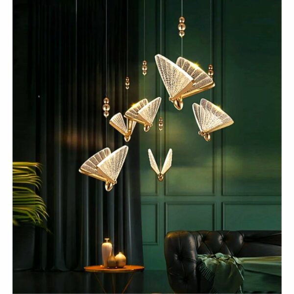 in een woonkamer met donkere bruingroene tinten zien we een gouden, transparante hanglamp in de vorm van een vlinder