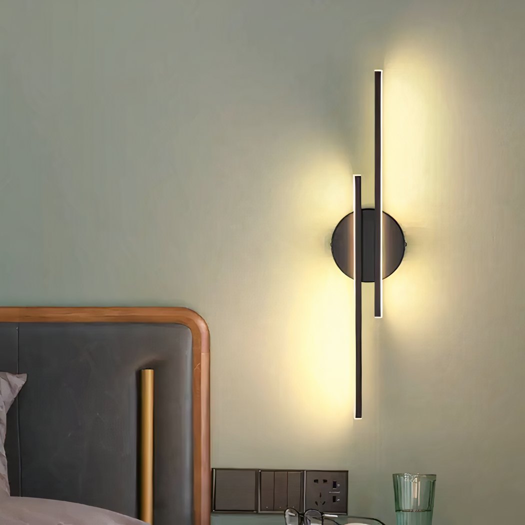 Moderne design lineaire wandlamp Moderne design lineaire wandlamp opgehangen aan een slaapkamermuur en verlicht, naast het bed.
