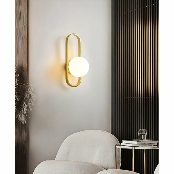in de woonkamer, met een witte fauteuil, ziet u een moderne gouden wandlamp met een bol